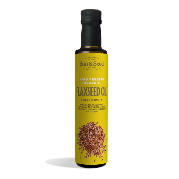 Tall dark glass bottle of Sun & Seed Cold Pressed Organic Flaxseed Oil featuring a bright yellow label with an illustration of flaxseeds at the bottom.