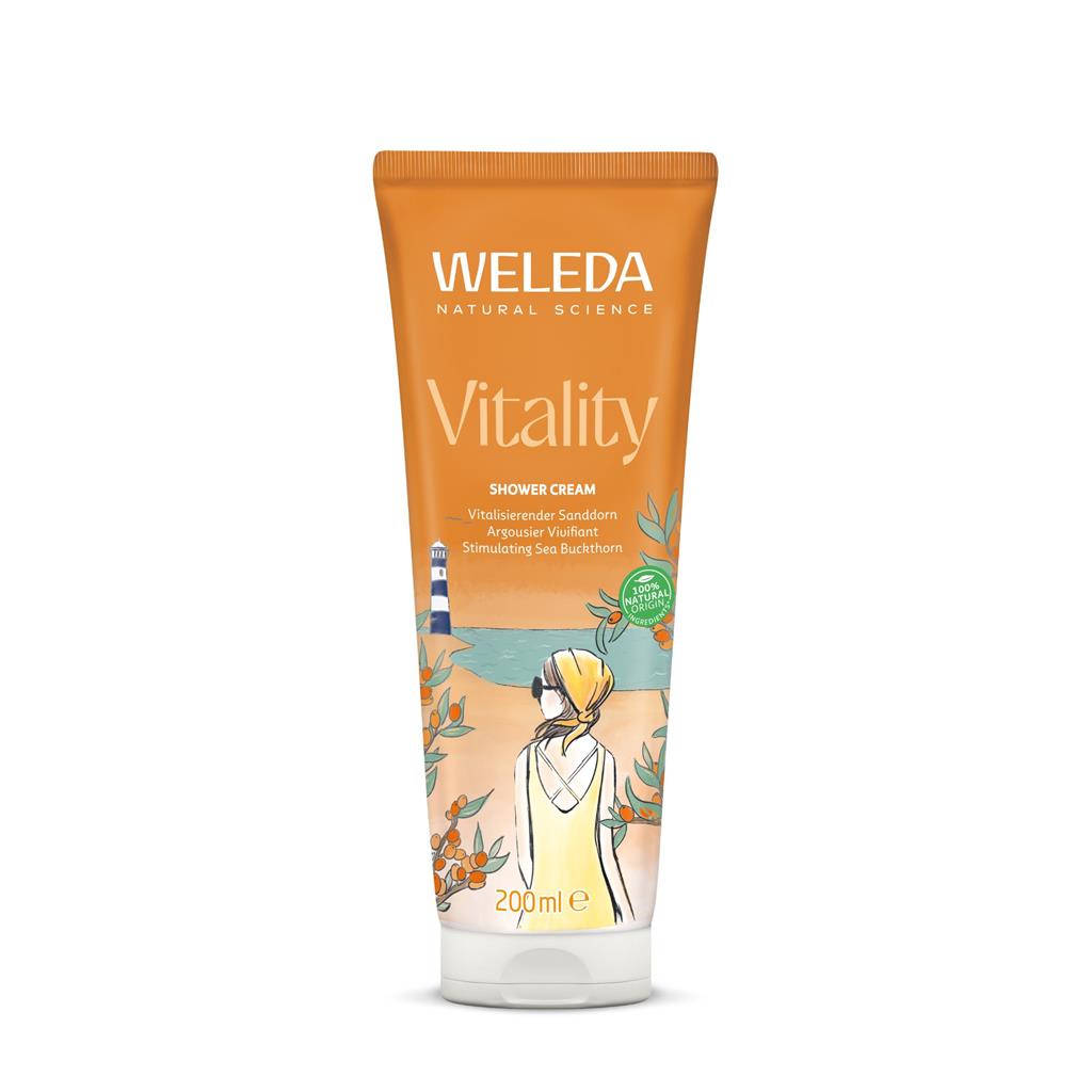An orange tube of Weleda Vitality Shower Cream featuring a summer-themed illustration of a woman at a beach with a lighthouse and sea buckthorn plants.