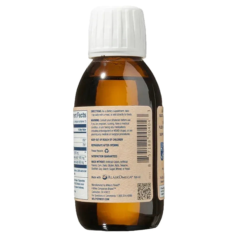 The back view of an amber glass bottle of Wiley's Finest Peak Omega-3 fish oil, showing the supplement facts, directions for use, a barcode, and a QR code on a tan label with a white ribbed cap.