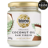 A jar of Biona Organic Raw Virgin Coconut Oil with a gold lid and tropical design, featuring palm leaves and coconut imagery. It has a "Great Taste 2024" award badge.