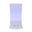 A tall, cylindrical white aroma diffuser with a rippled texture in the center, glowing with a soft purple light and featuring "Light" and "Mist" control buttons.