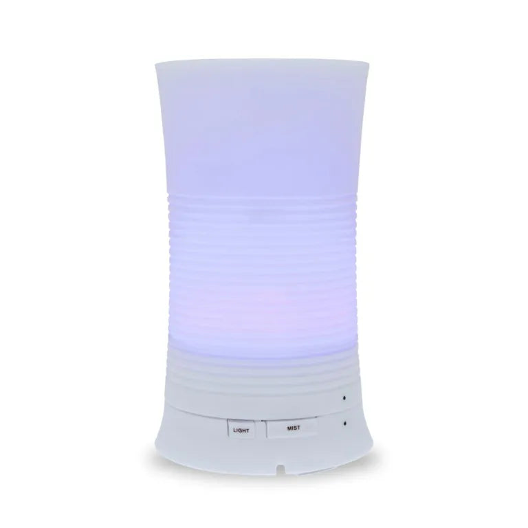 A tall, cylindrical white aroma diffuser with a rippled texture in the center, glowing with a soft purple light and featuring "Light" and "Mist" control buttons.