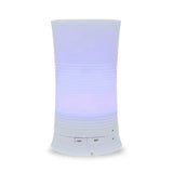 A tall, cylindrical white aroma diffuser with a rippled texture in the center, glowing with a soft purple light and featuring "Light" and "Mist" control buttons.