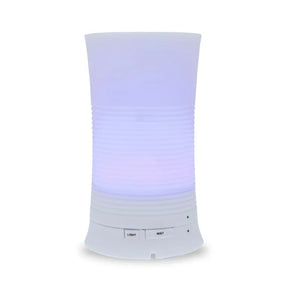 A tall, cylindrical white aroma diffuser with a rippled texture in the center, glowing with a soft purple light and featuring "Light" and "Mist" control buttons.