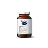 A 60-vegetable capsule amber glass jar of BioCare Methyl B Complex food supplement for energy, mental health, and hormone balance, featuring a white and purple label and silver cap, isolated on a white background.
