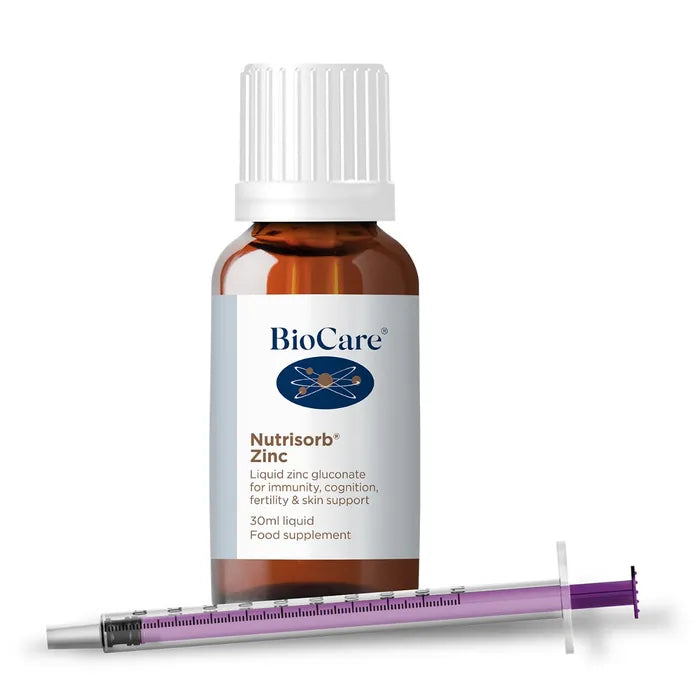 A 30ml amber glass bottle of BioCare Nutrisorb Zinc liquid zinc gluconate food supplement with a white label, white cap, and a measuring syringe with a purple plunger, isolated on a white background.