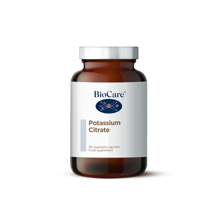 A 90-vegetable capsule amber glass jar of BioCare Potassium Citrate food supplement with a white and light grey label and silver cap, isolated on a white background.