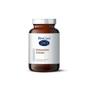 A 90-vegetable capsule amber glass jar of BioCare Potassium Citrate food supplement with a white and light grey label and silver cap, isolated on a white background.