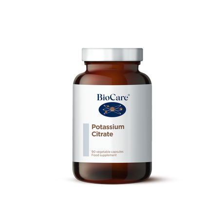 A 90-vegetable capsule amber glass jar of BioCare Potassium Citrate food supplement with a white and light grey label and silver cap, isolated on a white background.