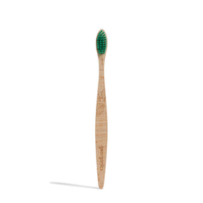 Wooden toothbrush with green bristles and engraved leaf pattern on the handle. The word "georganics" is etched into the handle, conveying an eco-friendly feel.