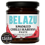 A jar of Belazu Smoked Chilli Harissa Paste on a white background, featuring a black lid, dark brown glass, and a white label with turquoise and red text and chili graphics. A circular 'great taste 2025' badge is overlaid in the bottom-left corner.