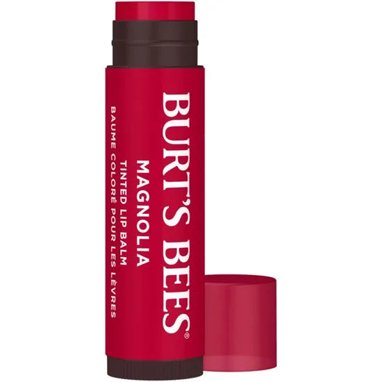 A Burt’s Bees Tinted Lip Balm in "Magnolia" shade, featuring a deep berry-pink tube with bold white vertical branding and a matching cap resting alongside. 