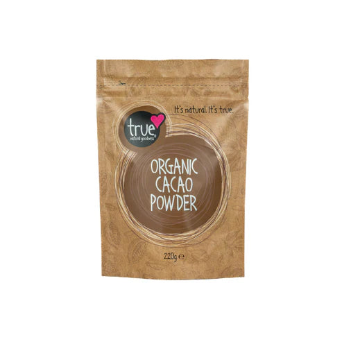 A 220g brown paper pouch of True Organic Cacao Powder with a brown circular logo and cacao bean illustrations.