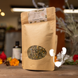 Kraft paper tea bag with Gystone Tea label on a wooden surface with blurred background