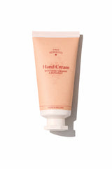 A peach-colored tube of Dublin Herbalists Hand Cream with Sweet Orange and Bergamot.