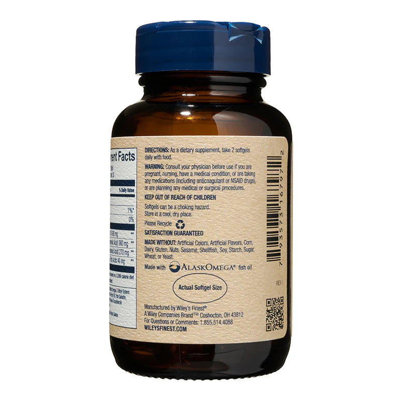 A side view of an amber glass bottle of Wiley's Finest Wild Alaskan Fish Oil with a blue cap. The label displays directions to take 2 softgels daily, a list of allergens the product is made without, and the AlaskOmega fish oil logo. An "Actual Softgel Size" graphic is visible near the bottom.