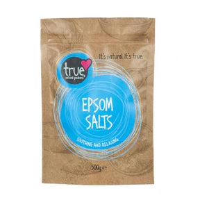 A 500g brown paper pouch of True Epsom Salts featuring a bright blue circular label with white line art and bowl illustrations.