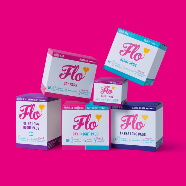 Flo menstrual product boxes against a vibrant pink background. Includes day, night, and daily liners with colorful, modern packaging design.
