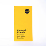A bright yellow rectangular box of Nobó Caramel Crunch plant-based chocolate, featuring a minimalist design with black text stating "Creamiest. Plant Based. Chocolate.