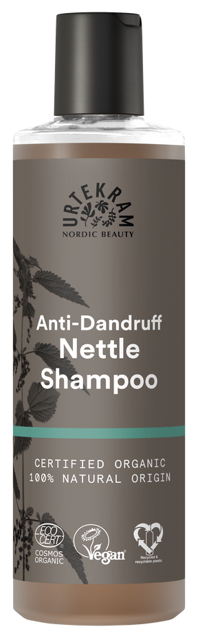 A tall bottle of Urtekram Anti-Dandruff Nettle Shampoo with a grey and brown label featuring a nettle leaf illustration. The bottle displays "Certified Organic" and "100% Natural Origin" labels alongside Vegan and Ecocert certifications.