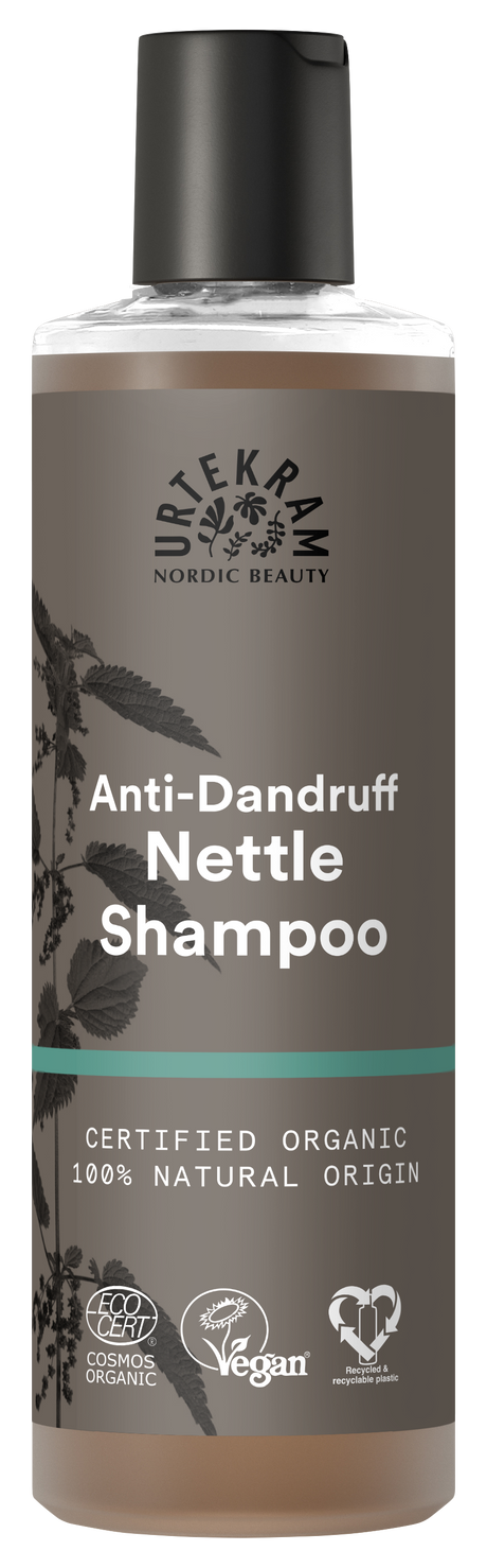 A tall bottle of Urtekram Anti-Dandruff Nettle Shampoo with a grey and brown label featuring a nettle leaf illustration. The bottle displays "Certified Organic" and "100% Natural Origin" labels alongside Vegan and Ecocert certifications.