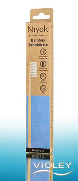 Niyok natural bamboo toothbrush in sustainable brown and blue eco-friendly cardboard packaging.