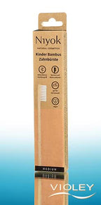 Niyok kids natural bamboo toothbrush in sustainable brown and peach cardboard packaging.