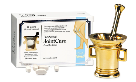 BioActive JointCare supplement packaging box with loose white tablets in front, shown beside a decorative gold mortar and pestle on a white background.