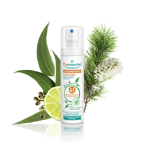 Puressentiel purifying air spray bottle surrounded by eucalyptus leaves, lime, and pine.