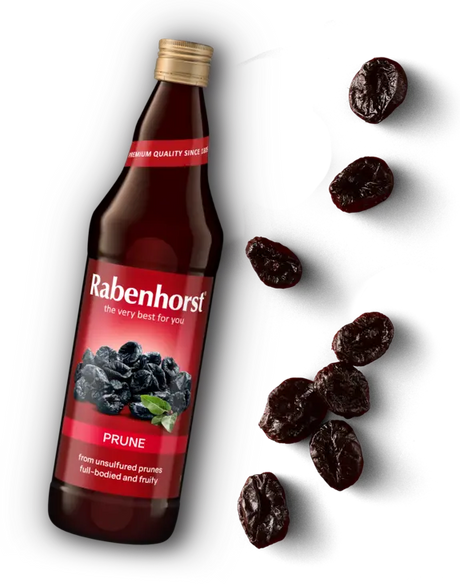 Glass bottle of Rabenhorst Prune juice with a red label, accompanied by scattered dried prunes.