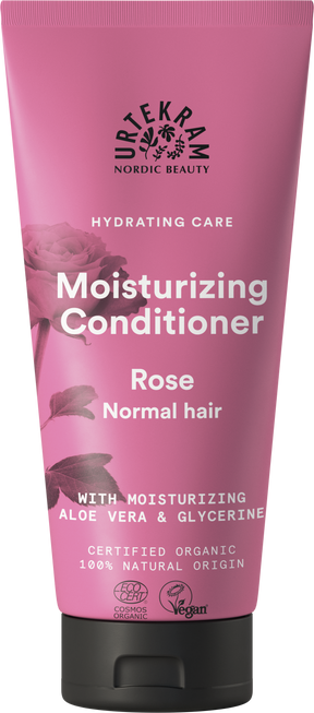 A rose-pink squeeze tube of Urtekram Moisturizing Conditioner for normal hair, featuring a rose illustration and the "Hydrating Care" tagline. The label indicates it contains moisturizing aloe vera and glycerine, is certified organic, 100% natural origin, and holds Vegan and Ecocert COSMOS Organic certifications.