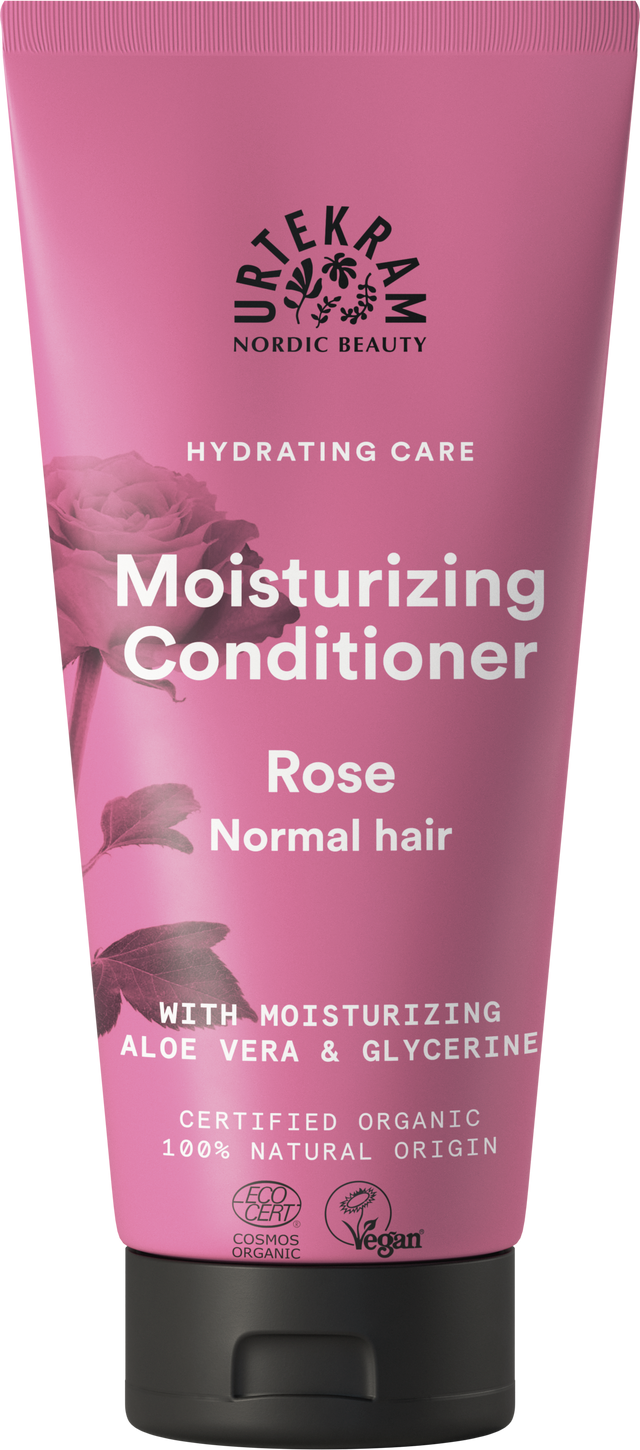 A rose-pink squeeze tube of Urtekram Moisturizing Conditioner for normal hair, featuring a rose illustration and the "Hydrating Care" tagline. The label indicates it contains moisturizing aloe vera and glycerine, is certified organic, 100% natural origin, and holds Vegan and Ecocert COSMOS Organic certifications.