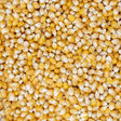 Close-up overhead view of a large pile of raw, dried yellow corn kernels.