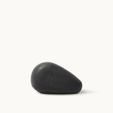 A dark rectangular bar of Sea Magik Black Mud Soap with an embossed logo.