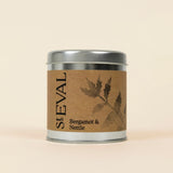 Small silver tin of St Eval Bergamot & Nettle candle featuring a brown kraft paper label.