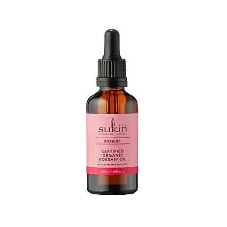 Sukin Rosehip Oil: Amber glass dropper bottle of Sukin Certified Organic Rosehip Oil, featuring a pink label with text identifying it as a 50ml treatment for dry and distressed skin types.