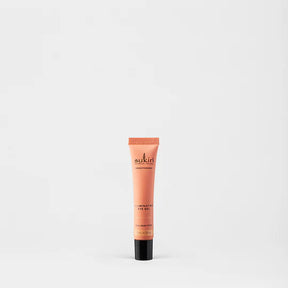 Sukin Brightening Illuminating Eye Gel in a peach tube with black cap.
