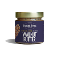 Small glass jar of Sun & Seed Organic Raw Walnut Butter featuring a gold lid and a dark purple label with a walnut heart graphic.