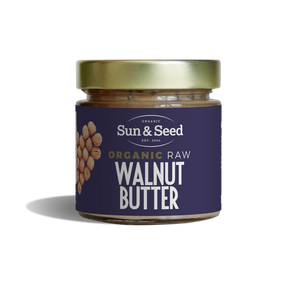 Small glass jar of Sun & Seed Organic Raw Walnut Butter featuring a gold lid and a dark purple label with a walnut heart graphic.