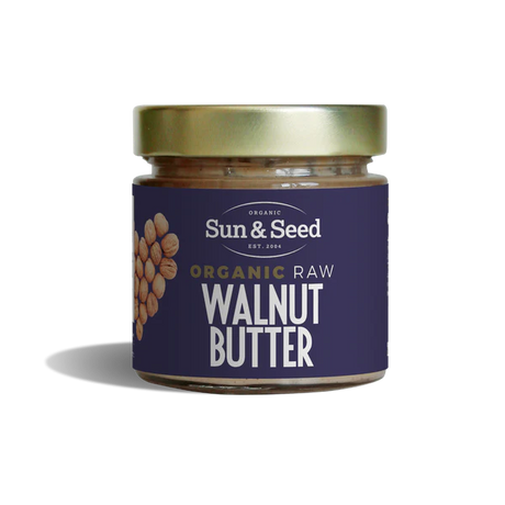 Small glass jar of Sun & Seed Organic Raw Walnut Butter featuring a gold lid and a dark purple label with a walnut heart graphic.