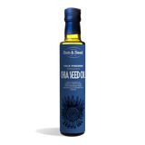 Tall dark glass bottle of Sun & Seed Cold Pressed Organic Chia Seed Oil featuring a deep blue label with an intricate feathered circular graphic at the bottom.