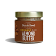 Small glass jar of Sun & Seed Organic Raw Almond Butter featuring a gold lid and brown label.