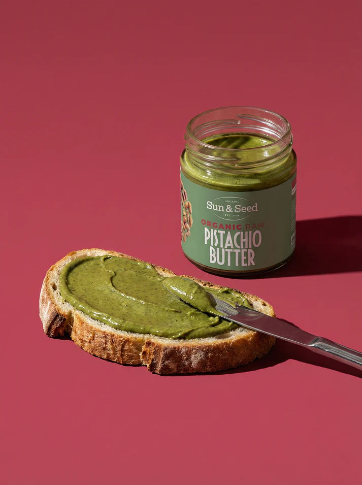 Small glass jar of Sun & Seed Pumpkin Seed Butter with gold lid and green label.
