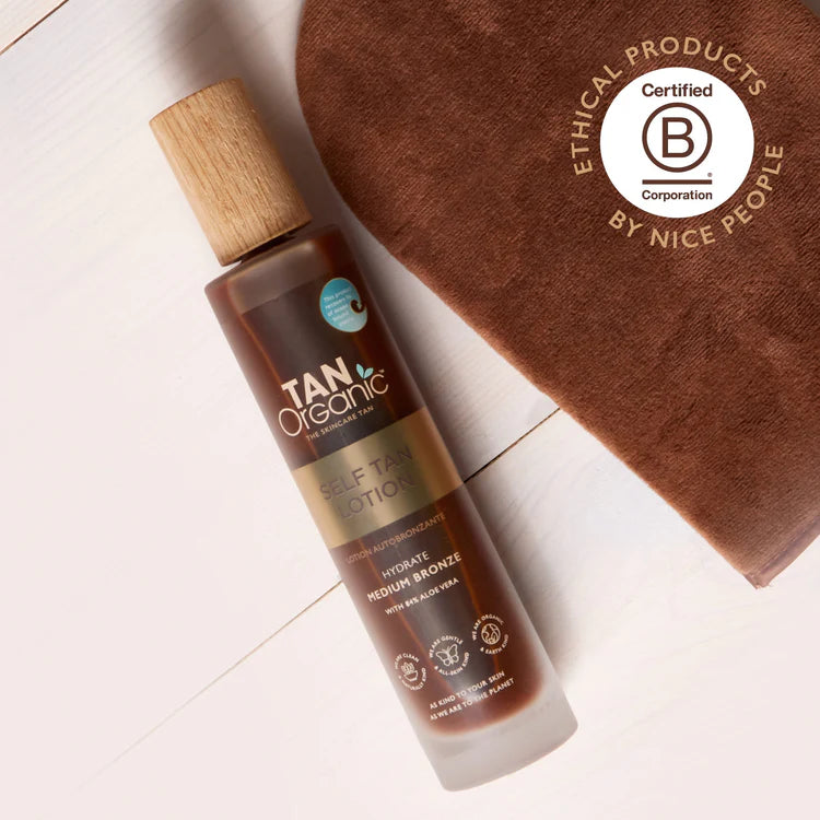 TanOrganic Self Tan Lotion bottle beside tanning mitt.