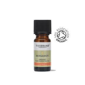 A small amber glass bottle of Tisserand Bergamot organic pure essential oil with a pale green and white label and a black cap.