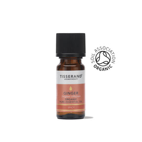 A small amber glass bottle of Tisserand Ginger organic pure essential oil with a terracotta and white label and a black cap.