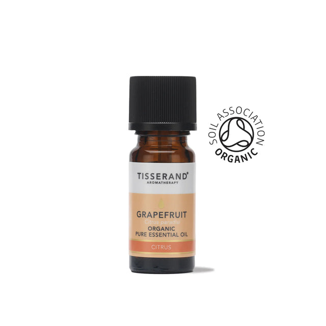 A small amber glass bottle of Tisserand Grapefruit organic pure essential oil with a peach and white label and a black cap.