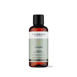 100ml amber glass bottle of Tisserand Jojoba oil with a sage green and white label and a black screw cap.