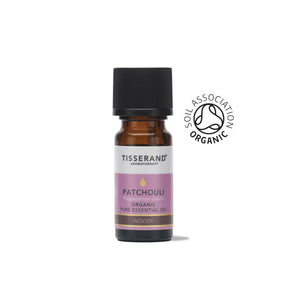 A small amber glass bottle of Tisserand Patchouli organic pure essential oil with a purple and white label and a black cap.