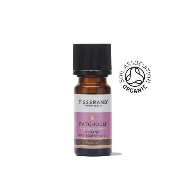 A small amber glass bottle of Tisserand Patchouli organic pure essential oil with a purple and white label and a black cap.
